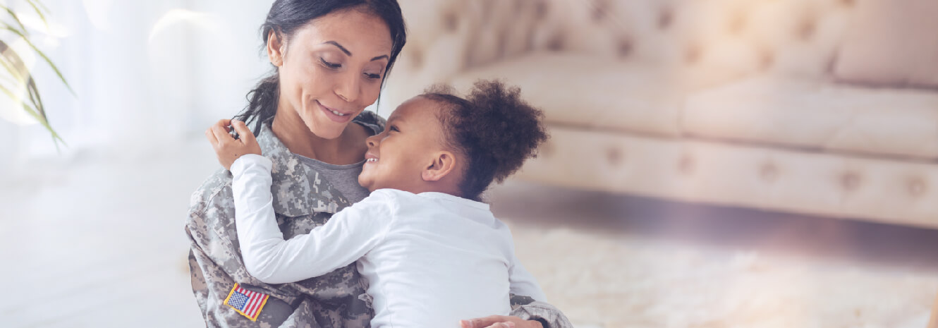 military woman holding child in her arms